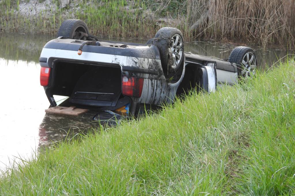 Auto op zijn kop in de sloot
