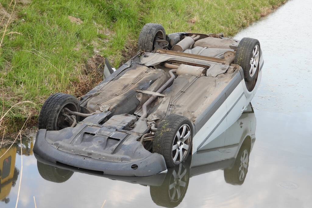 Auto op zijn kop in de sloot