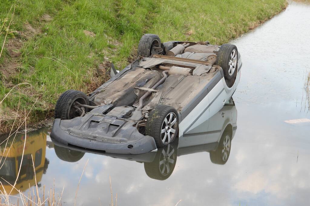 Auto op zijn kop in de sloot