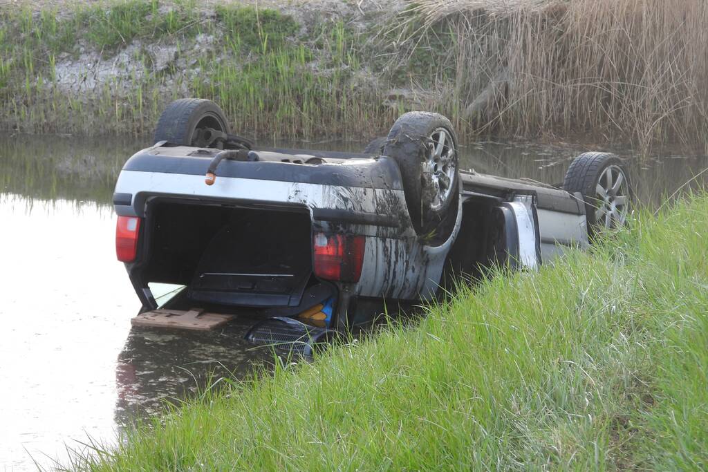 Auto op zijn kop in de sloot
