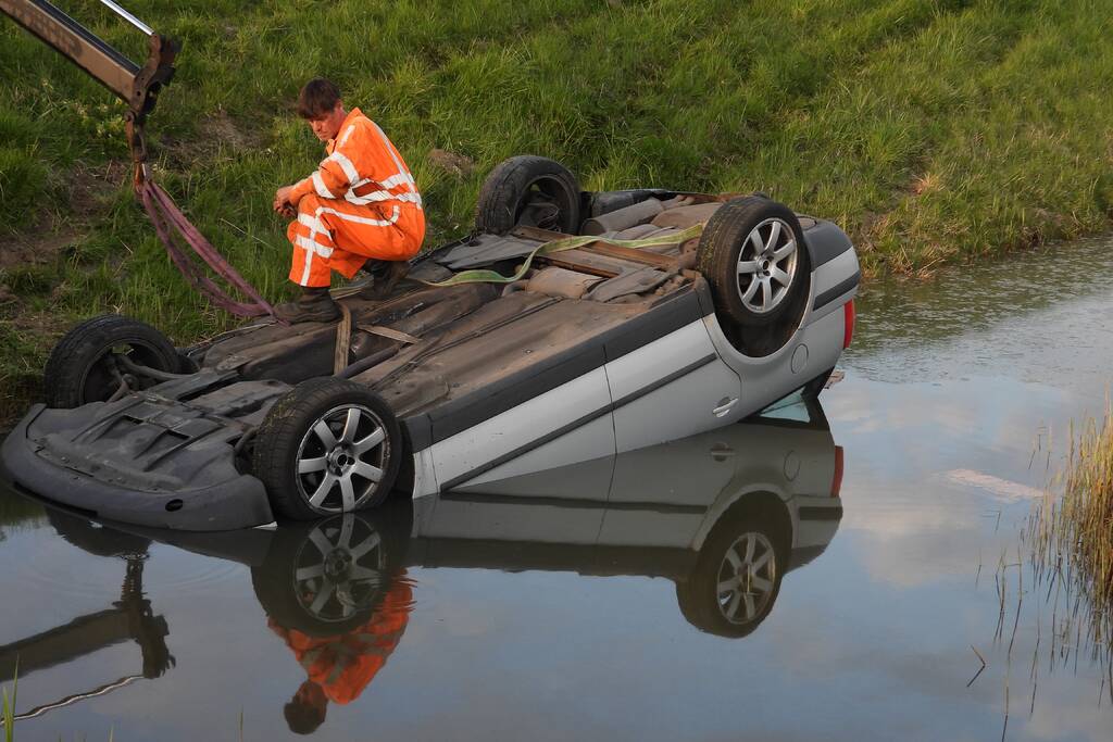 Auto op zijn kop in de sloot
