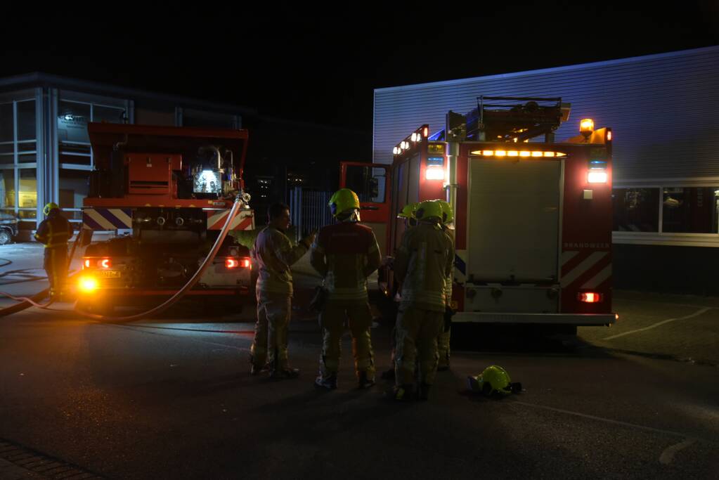 Meerdere voertuigen in brand tegen gevel bedrijfspand