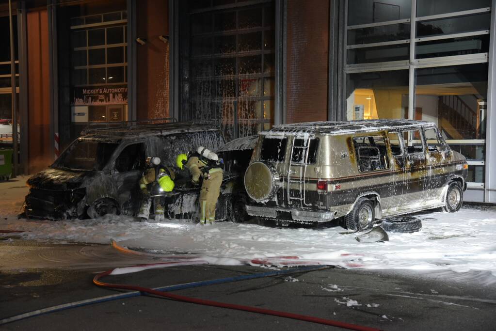 Meerdere voertuigen in brand tegen gevel bedrijfspand