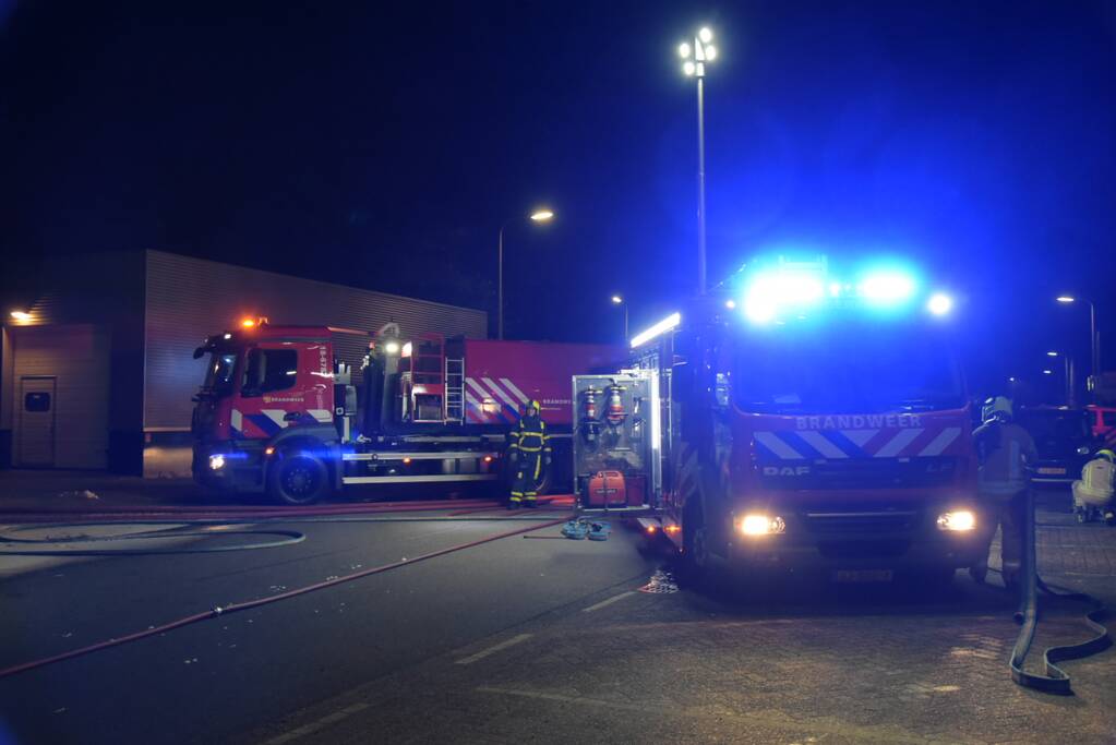 Meerdere voertuigen in brand tegen gevel bedrijfspand