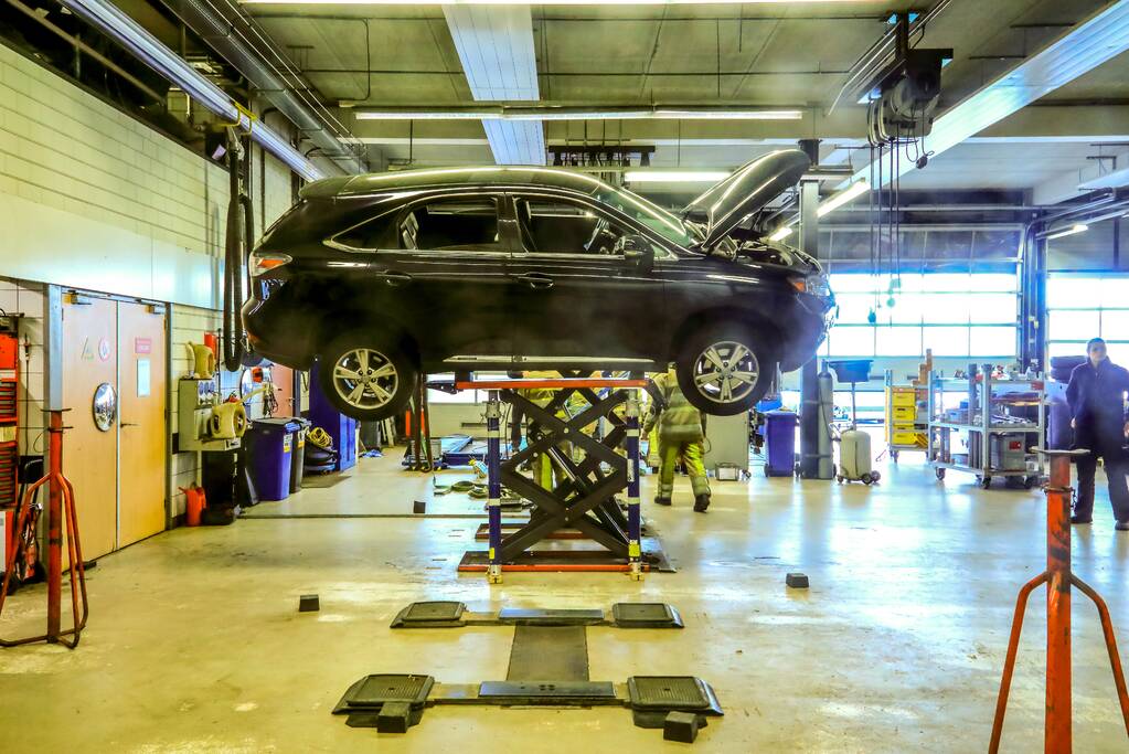 Auto dreigt van hefbrug Toyota Louwman af te vallen