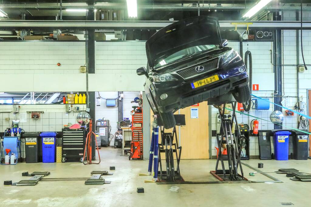 Auto dreigt van hefbrug Toyota Louwman af te vallen