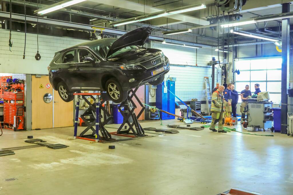 Auto dreigt van hefbrug Toyota Louwman af te vallen