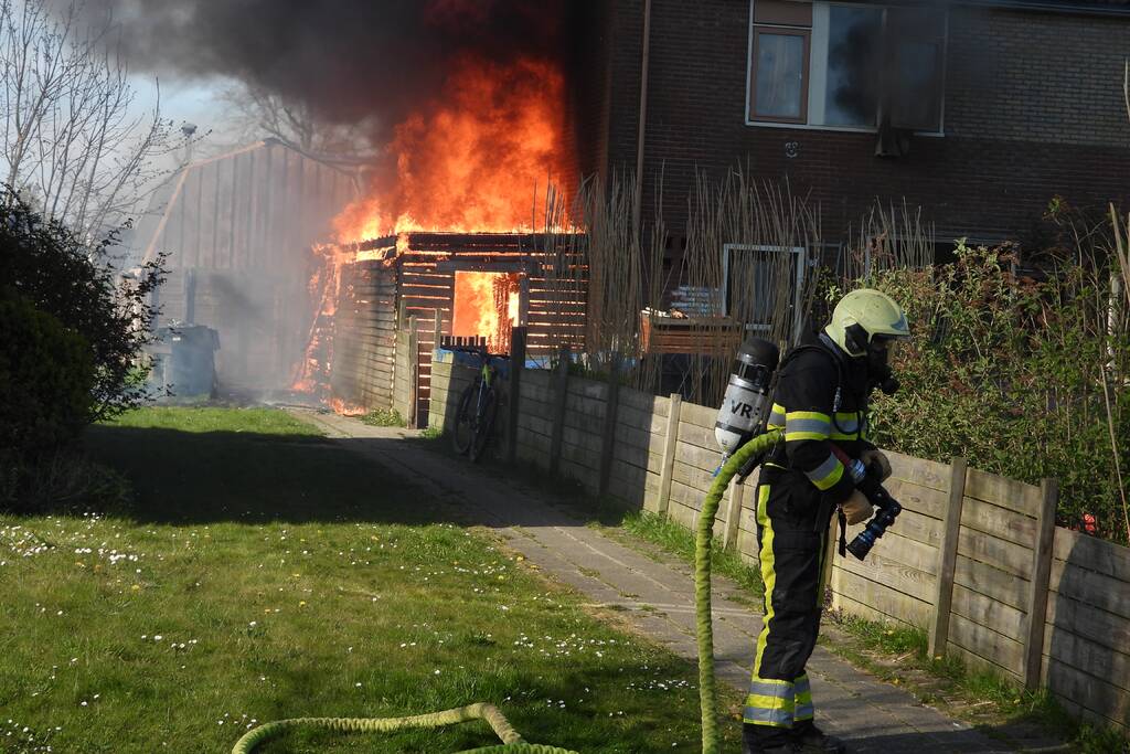 Uitslaande brand in schuur tegen woning aan