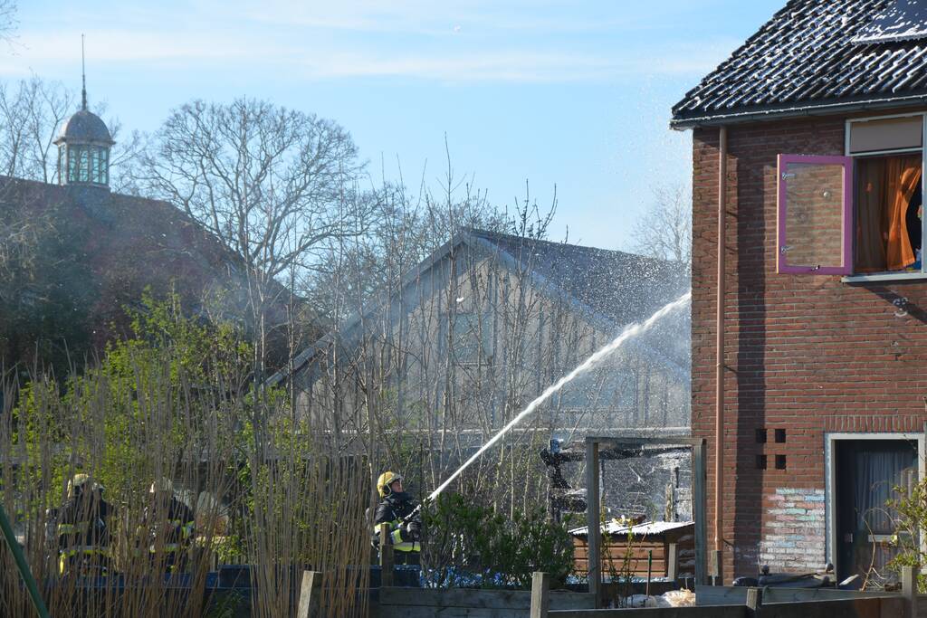 Uitslaande brand in schuur tegen woning aan