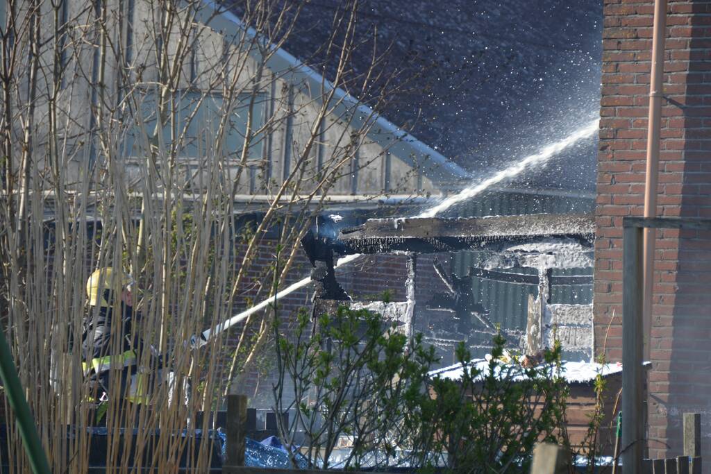 Uitslaande brand in schuur tegen woning aan