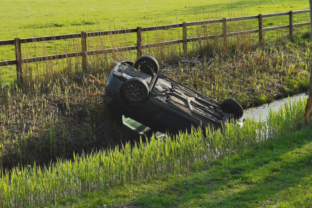 Auto op de kop in de sloot
