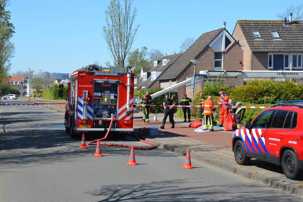 Brandweer in beschermende pakken halen persoon uit woning