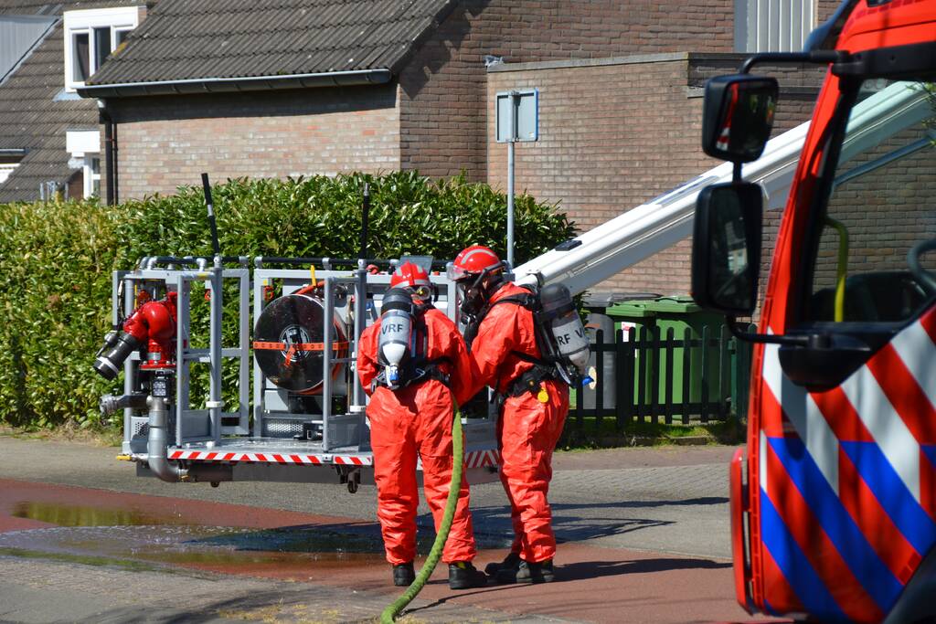Brandweer in beschermende pakken halen persoon uit woning