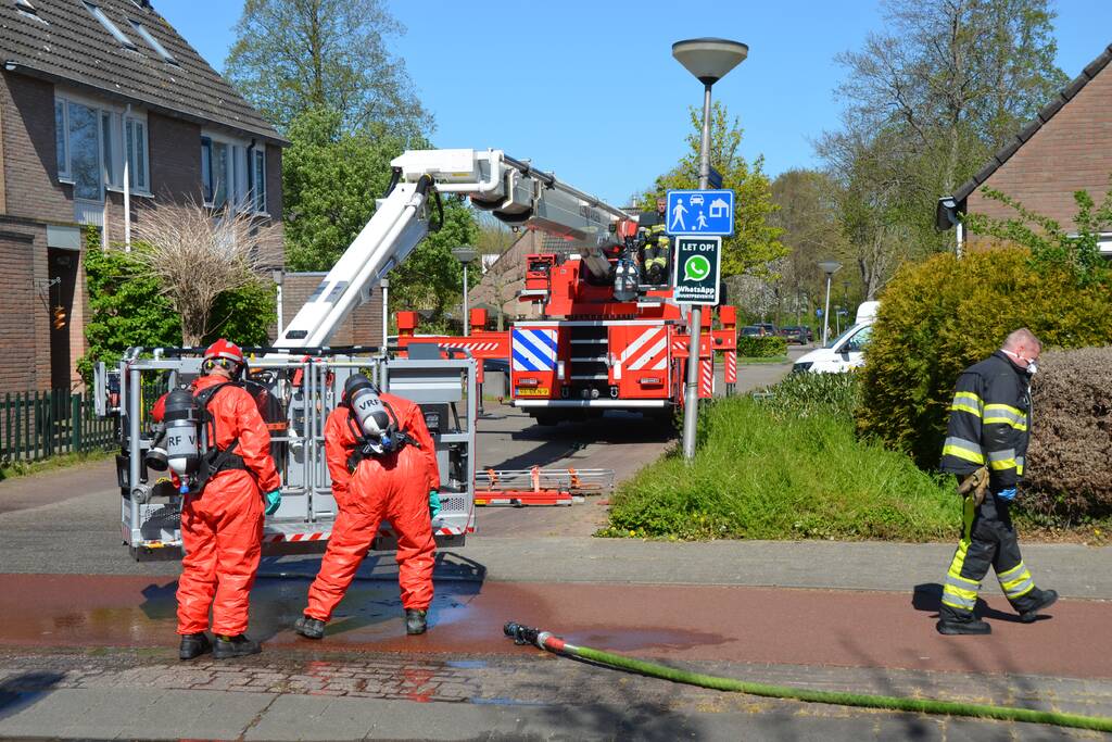 Brandweer in beschermende pakken halen persoon uit woning