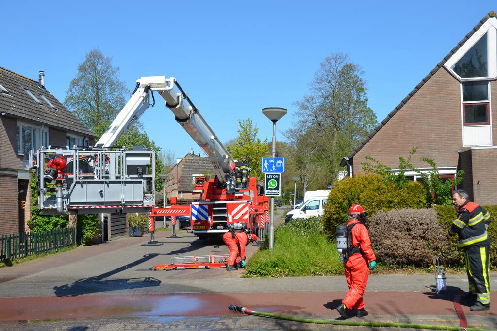 Brandweer in beschermende pakken halen persoon uit woning