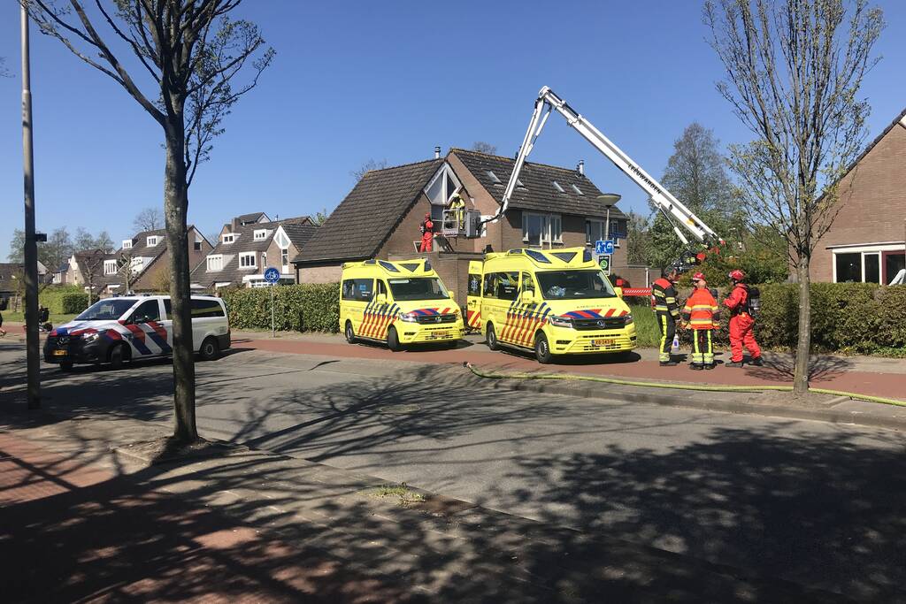 Brandweer in beschermende pakken halen persoon uit woning