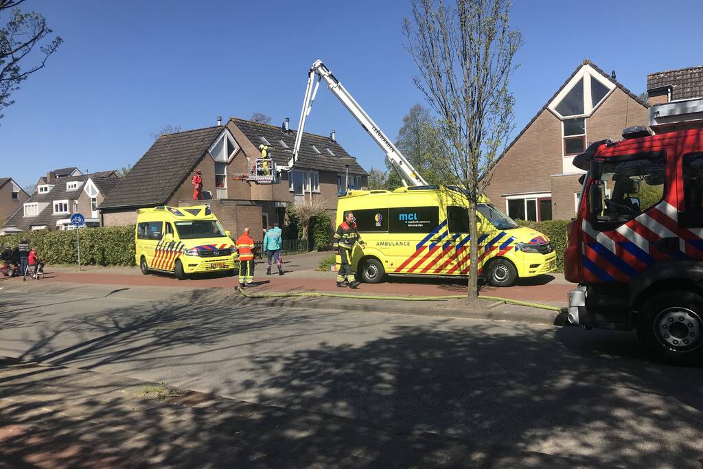 Brandweer in beschermende pakken halen persoon uit woning