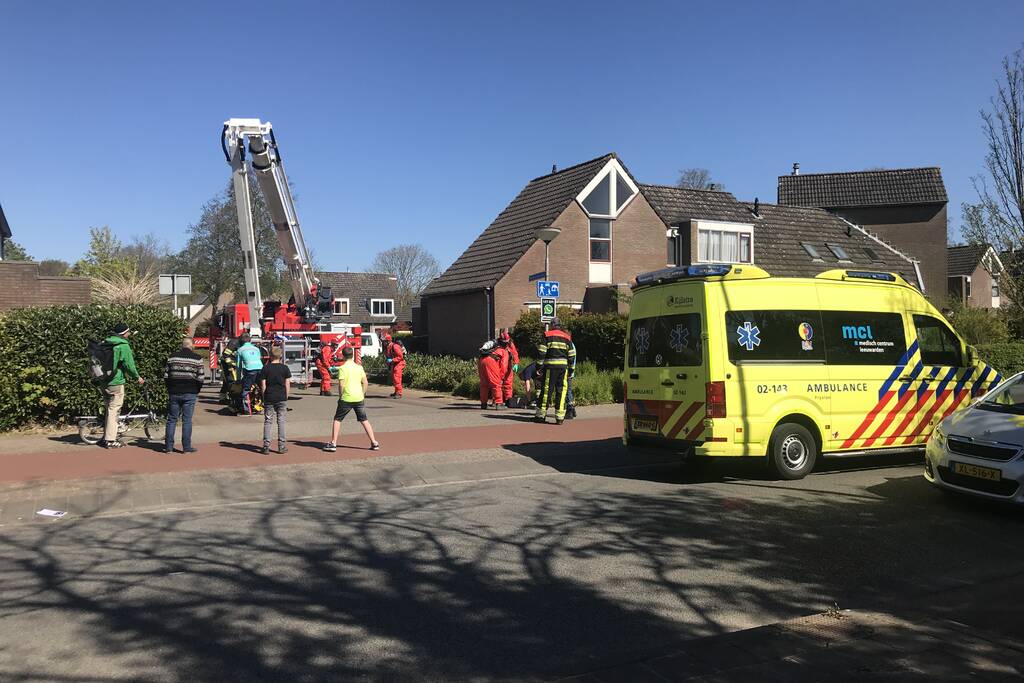 Brandweer in beschermende pakken halen persoon uit woning