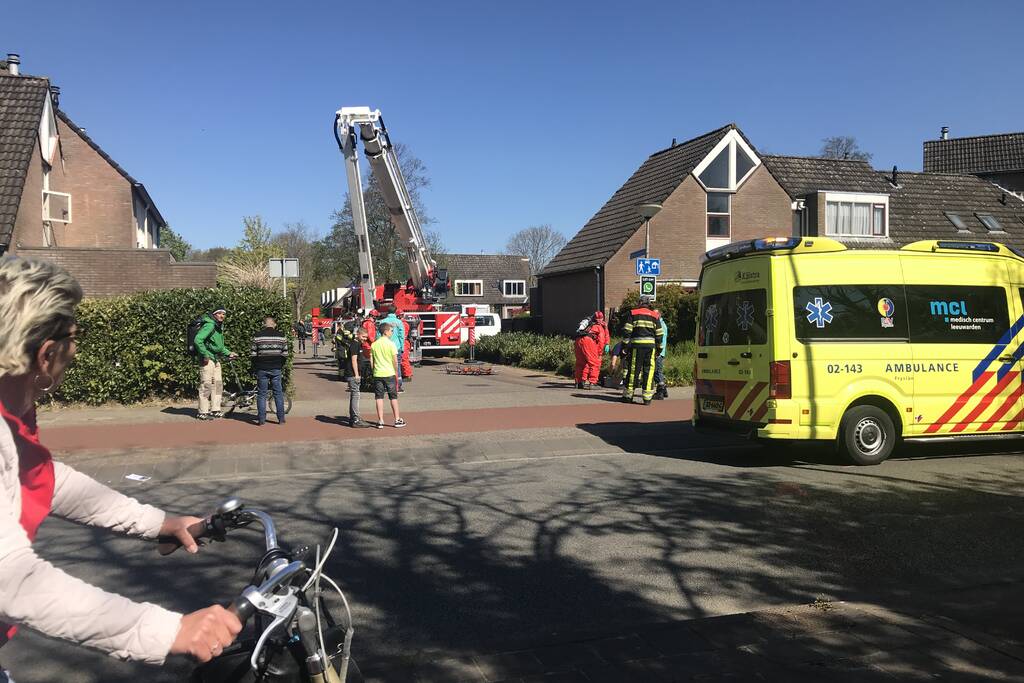 Brandweer in beschermende pakken halen persoon uit woning