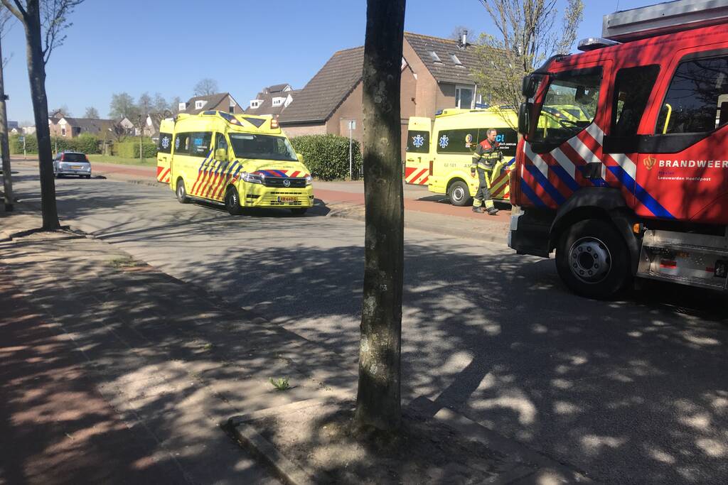 Brandweer in beschermende pakken halen persoon uit woning