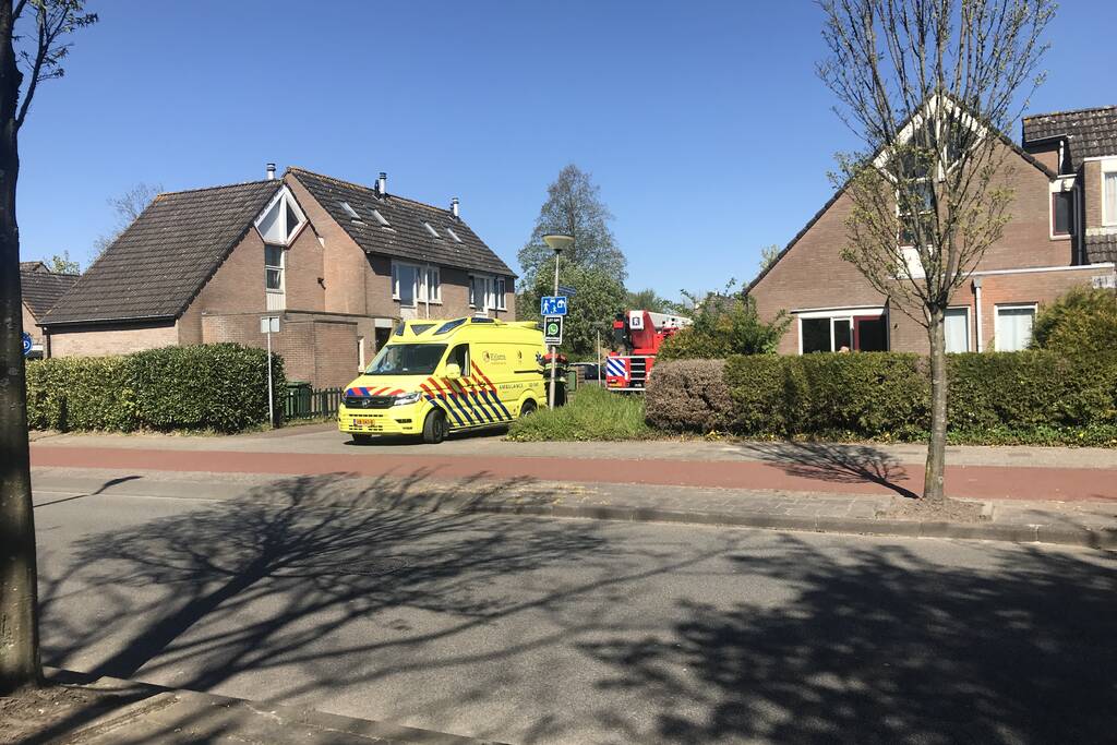Brandweer in beschermende pakken halen persoon uit woning