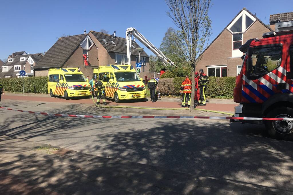 Brandweer in beschermende pakken halen persoon uit woning