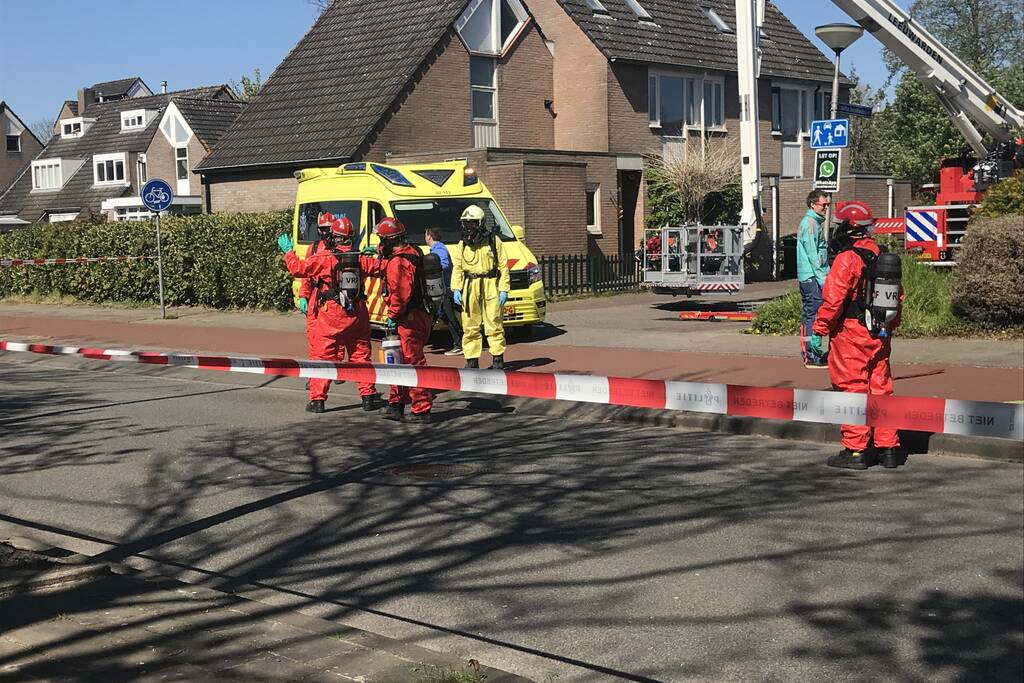 Brandweer in beschermende pakken halen persoon uit woning