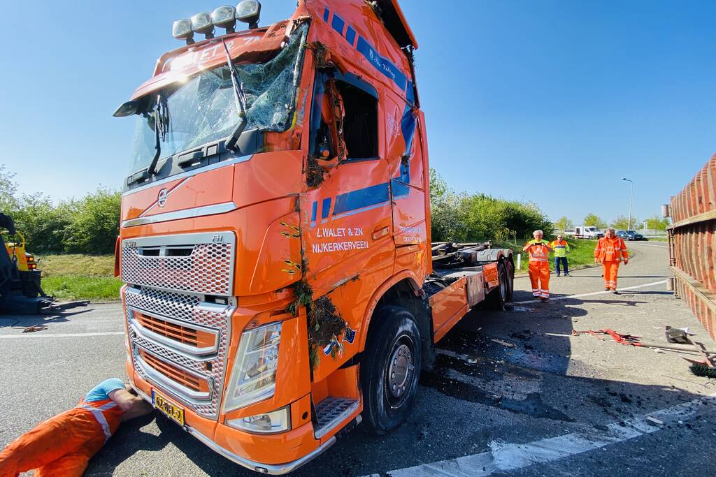Vrachtwagen met afval gekanteld op afrit