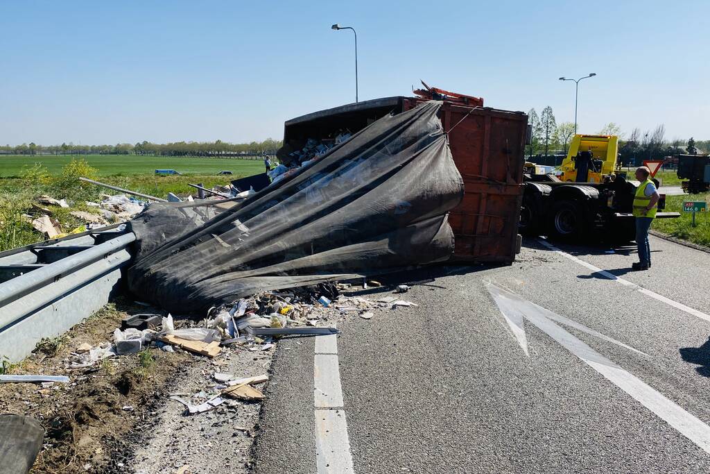 Vrachtwagen met afval gekanteld op afrit