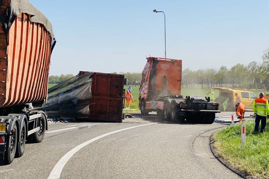 Vrachtwagen met afval gekanteld op afrit