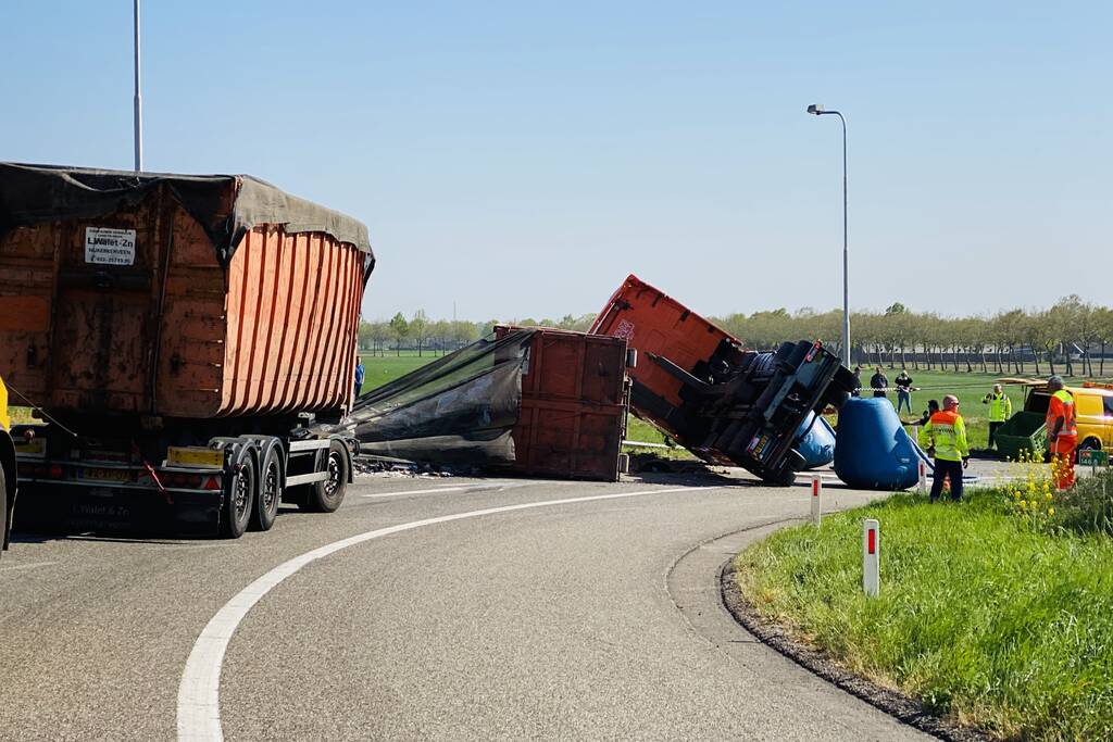Vrachtwagen met afval gekanteld op afrit