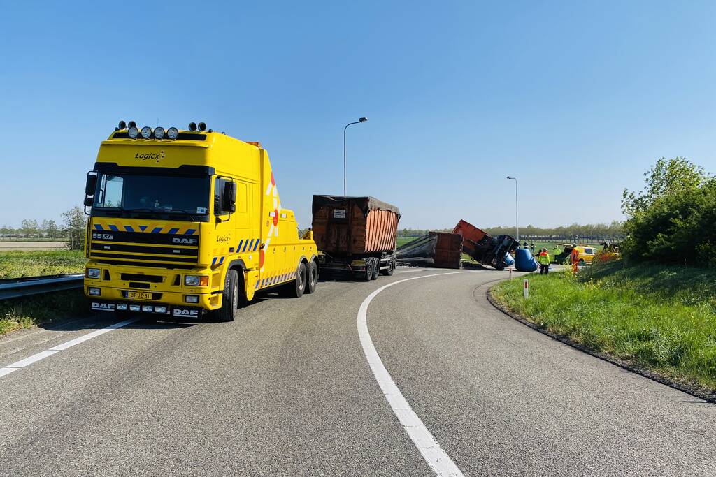 Vrachtwagen met afval gekanteld op afrit