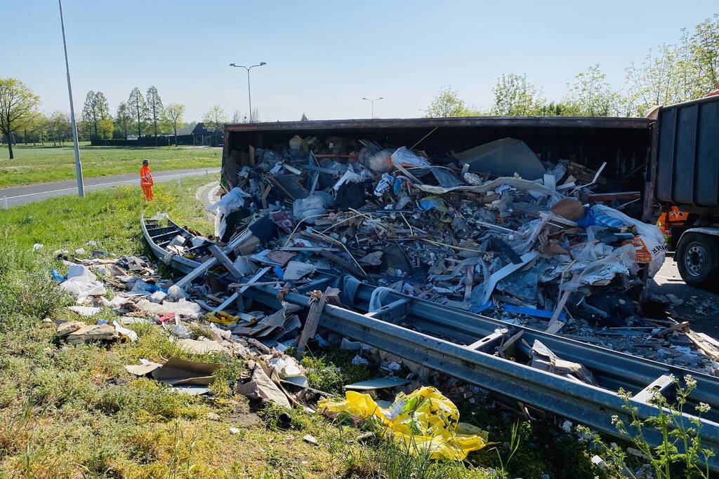 Vrachtwagen met afval gekanteld op afrit