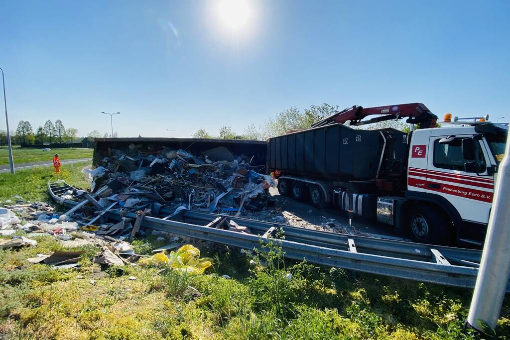 Vrachtwagen met afval gekanteld op afrit
