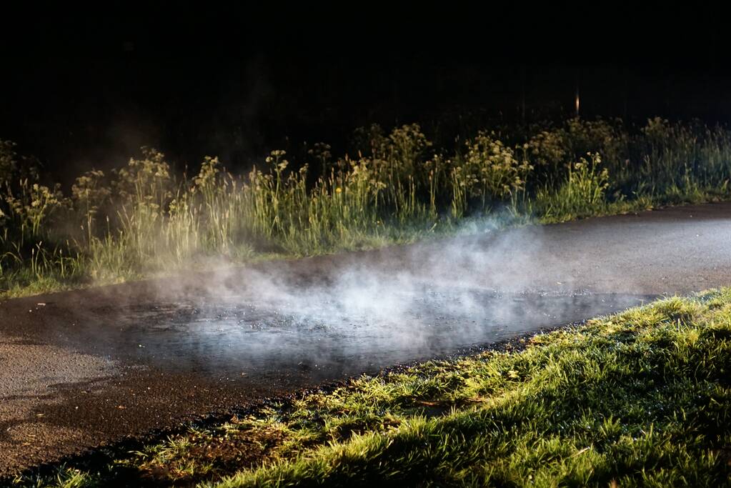 Brandweer blust brandend asfalt