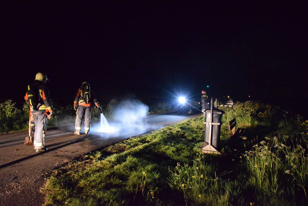 Brandweer blust brandend asfalt