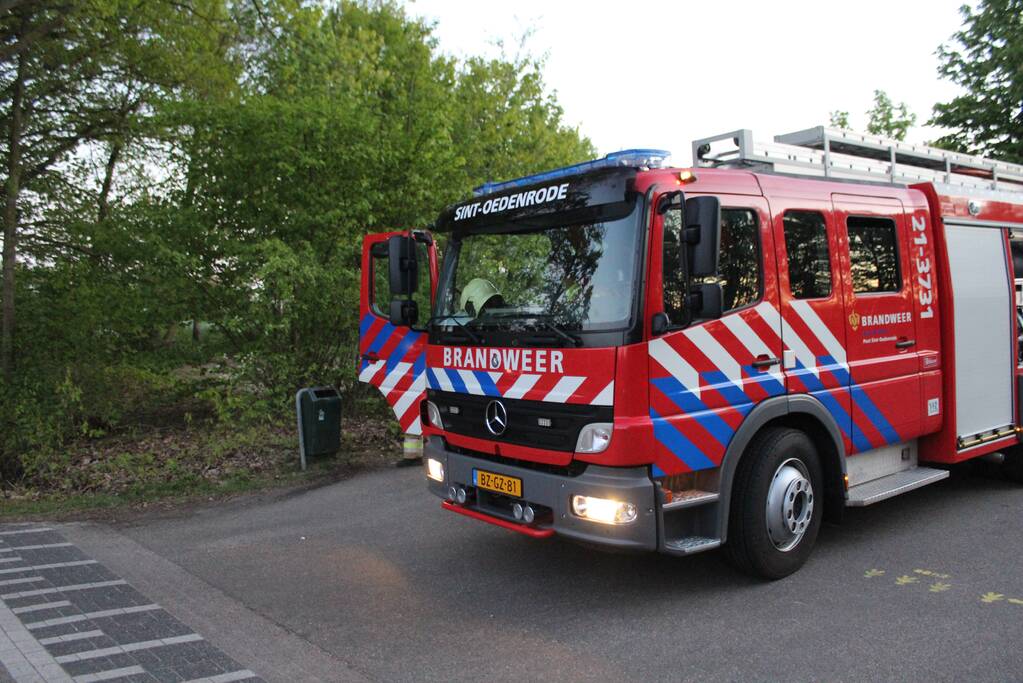 Omstanders doven vuur in prullenbak op parkeerterrein