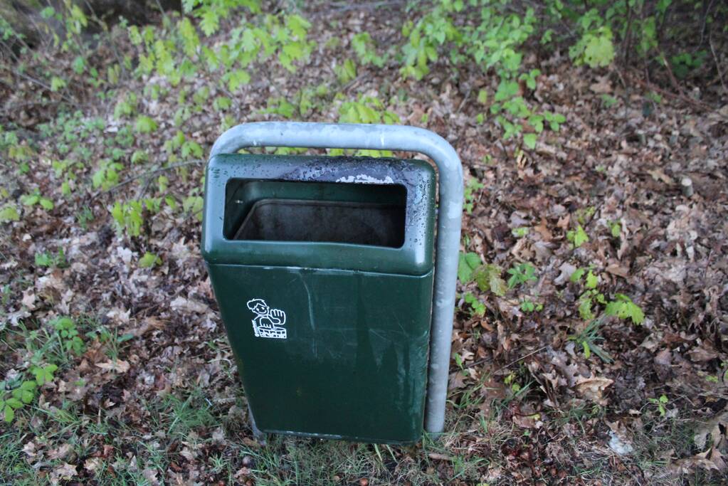 Omstanders doven vuur in prullenbak op parkeerterrein