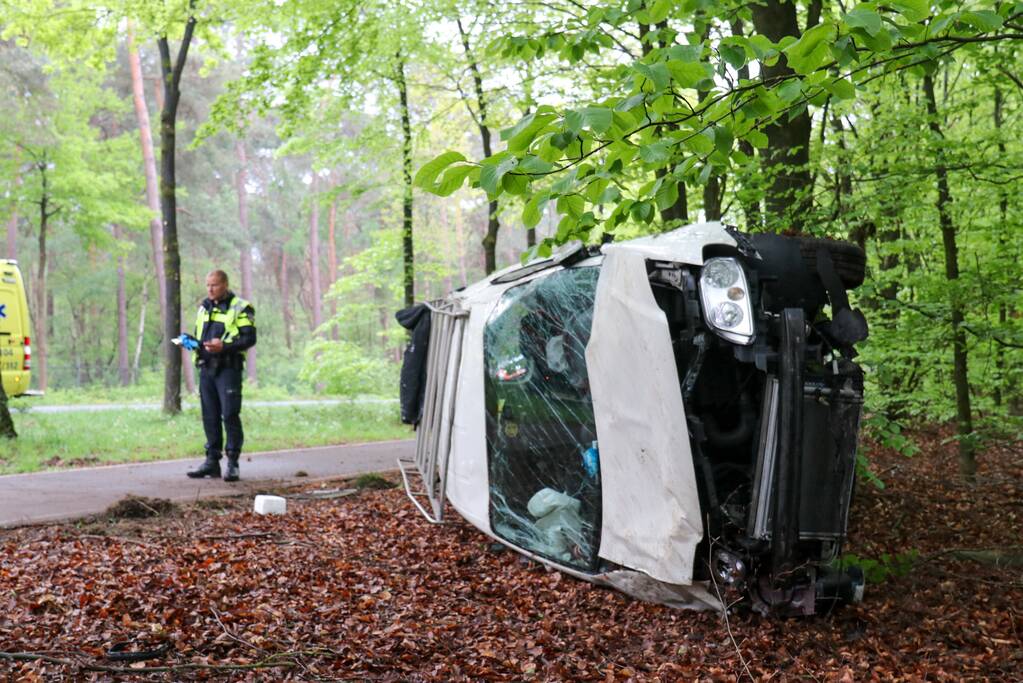 Bestelbus belandt op zijn kant in bosschage