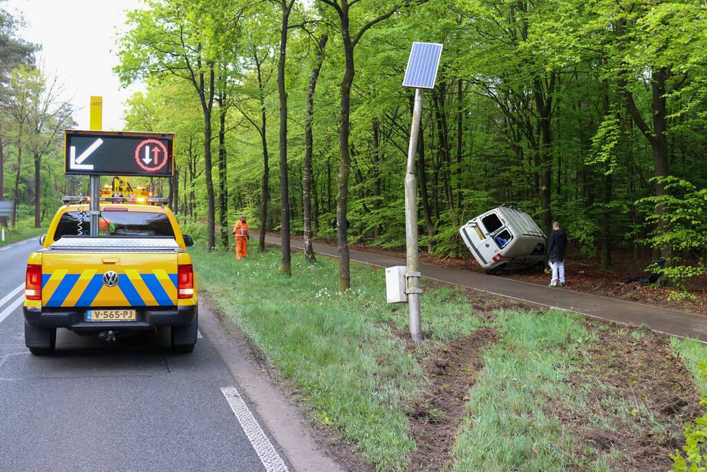 Bestelbus belandt op zijn kant in bosschage