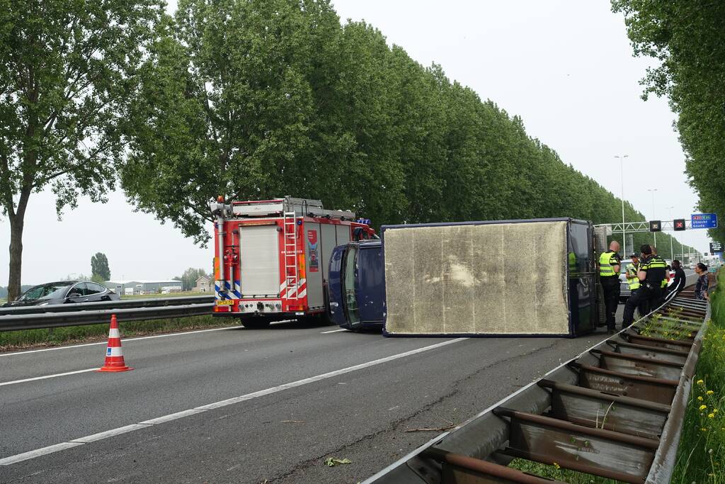 Bestelbus belandt op zijn kant, vrachtwagen ramt vangrail