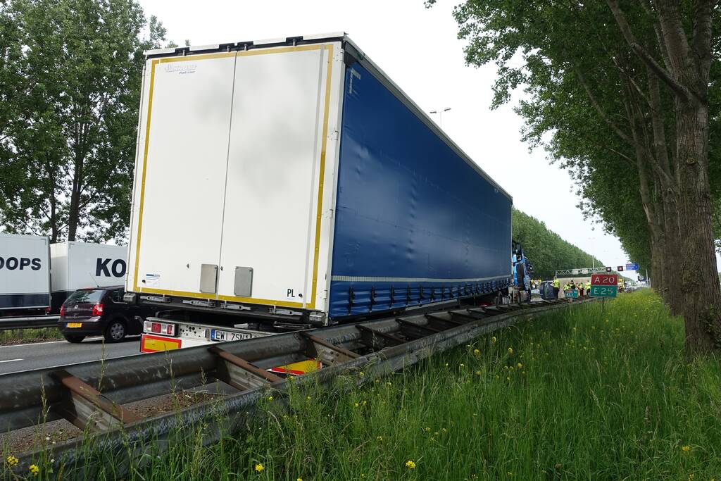 Bestelbus belandt op zijn kant, vrachtwagen ramt vangrail