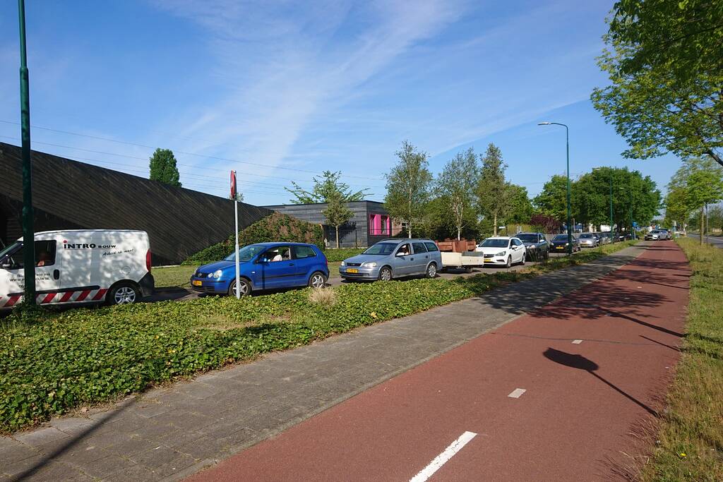 Wachtrij op fietspad bij vuilstort