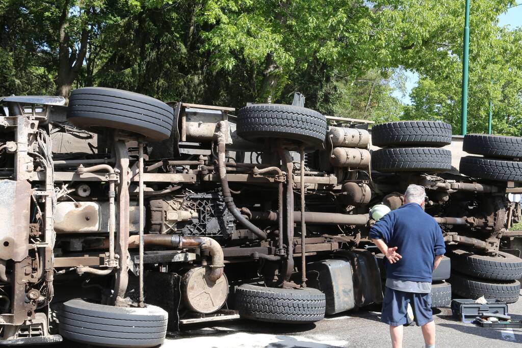 Vrachtwagen met tuinafval gekanteld op rotonde