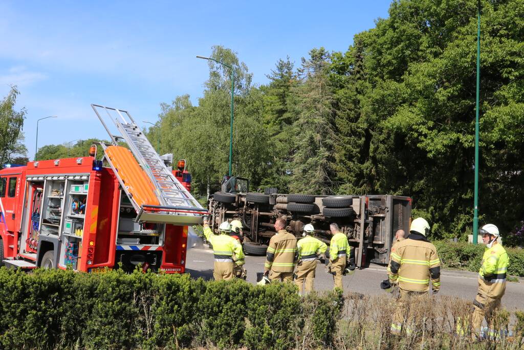 Vrachtwagen met tuinafval gekanteld op rotonde