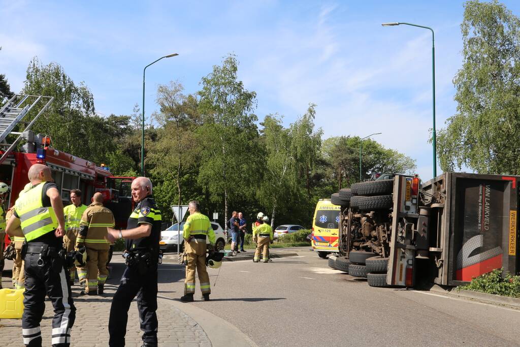 Vrachtwagen met tuinafval gekanteld op rotonde