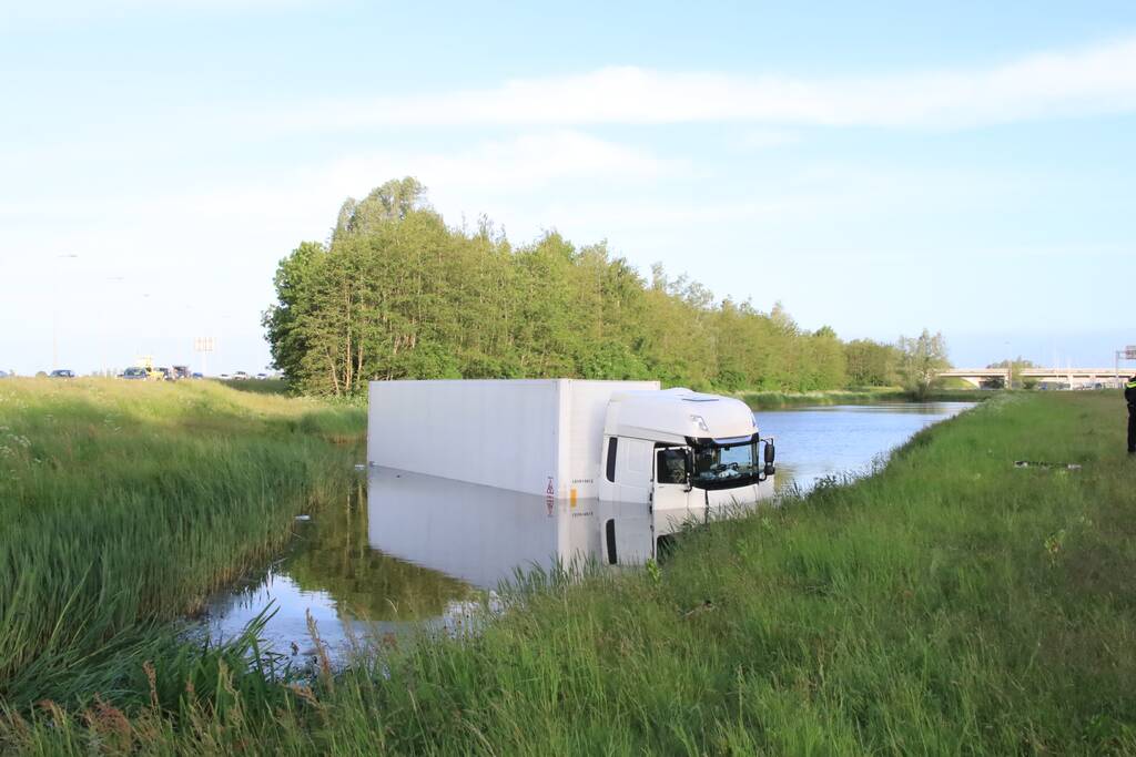 Vrachtwagen PostNL belandt in sloot