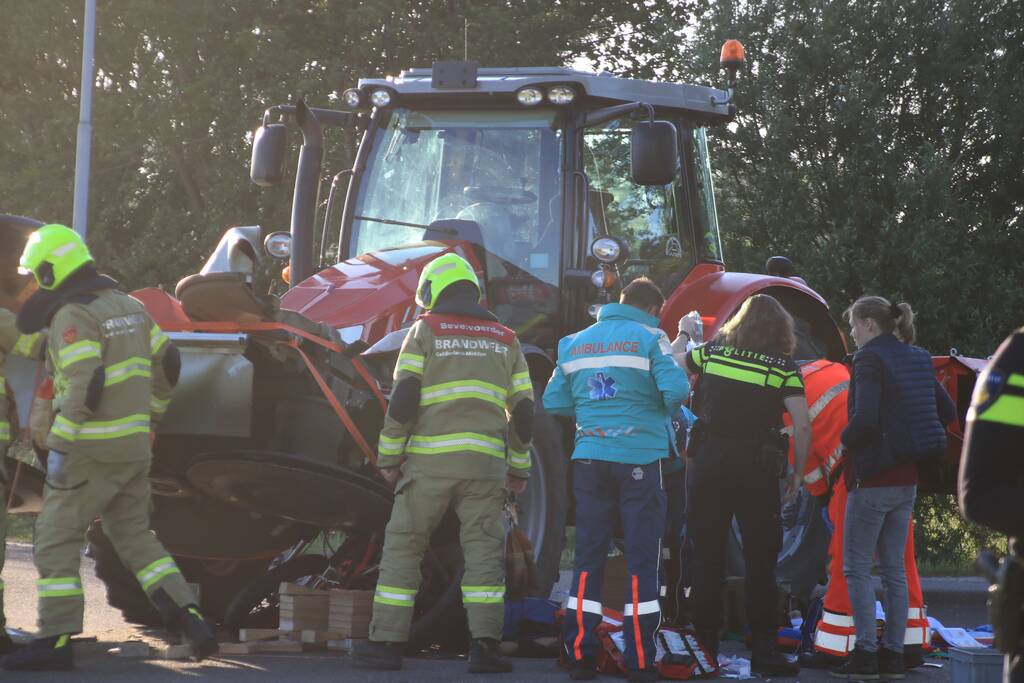 Scooter en scooterrijder bekneld onder tractor na ongeval