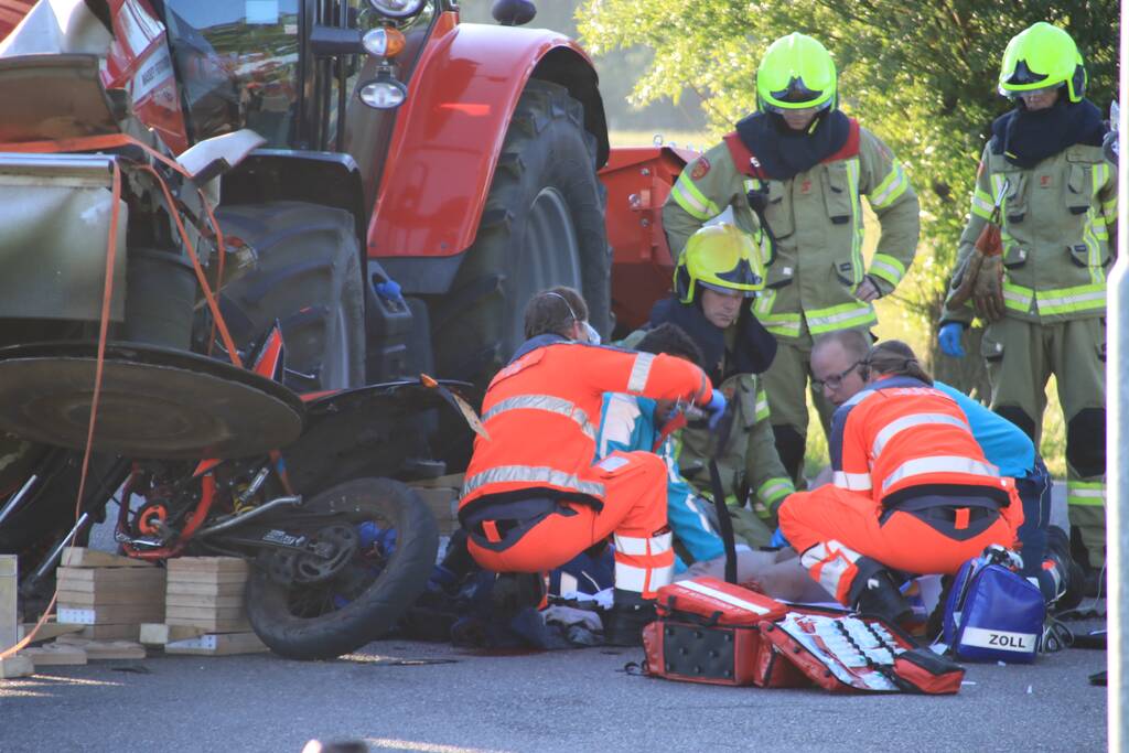 Scooter en scooterrijder bekneld onder tractor na ongeval