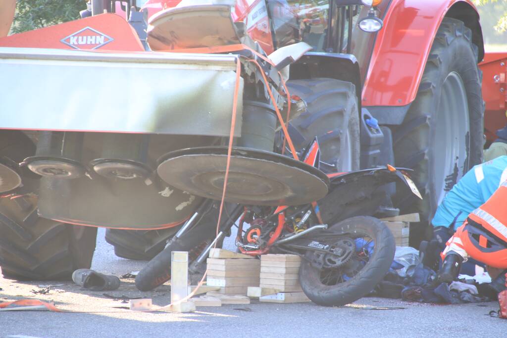 Scooter en scooterrijder bekneld onder tractor na ongeval